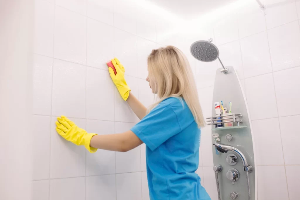 Blonde woman employee cleaning company wearing in yellow protective rubber gloves with special cleaning sponge